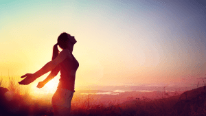 Woman running with her hands out during a sunset