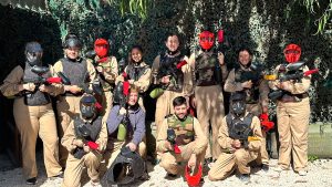 group of people smiling with paintball equipment