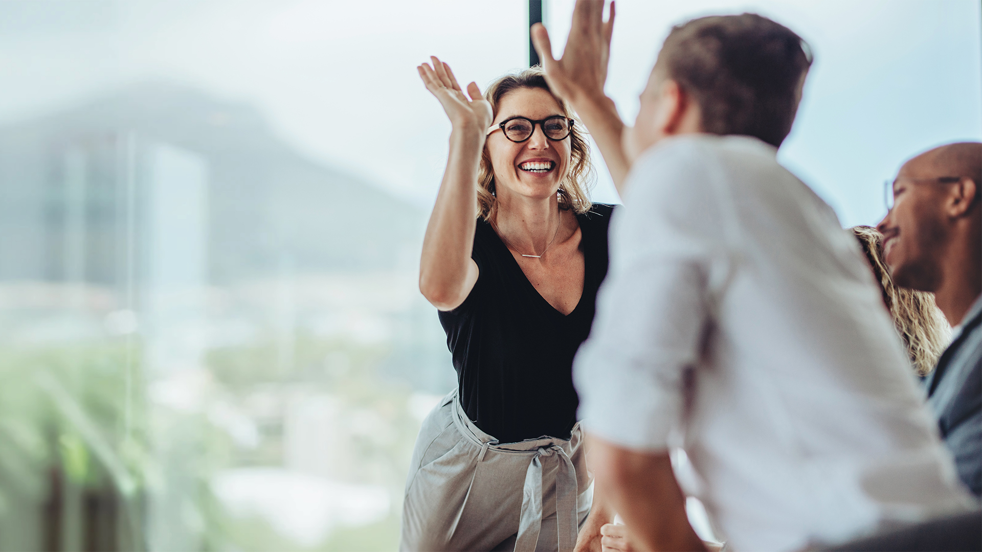 Businesswoman giving a high five to a colleague in meeting